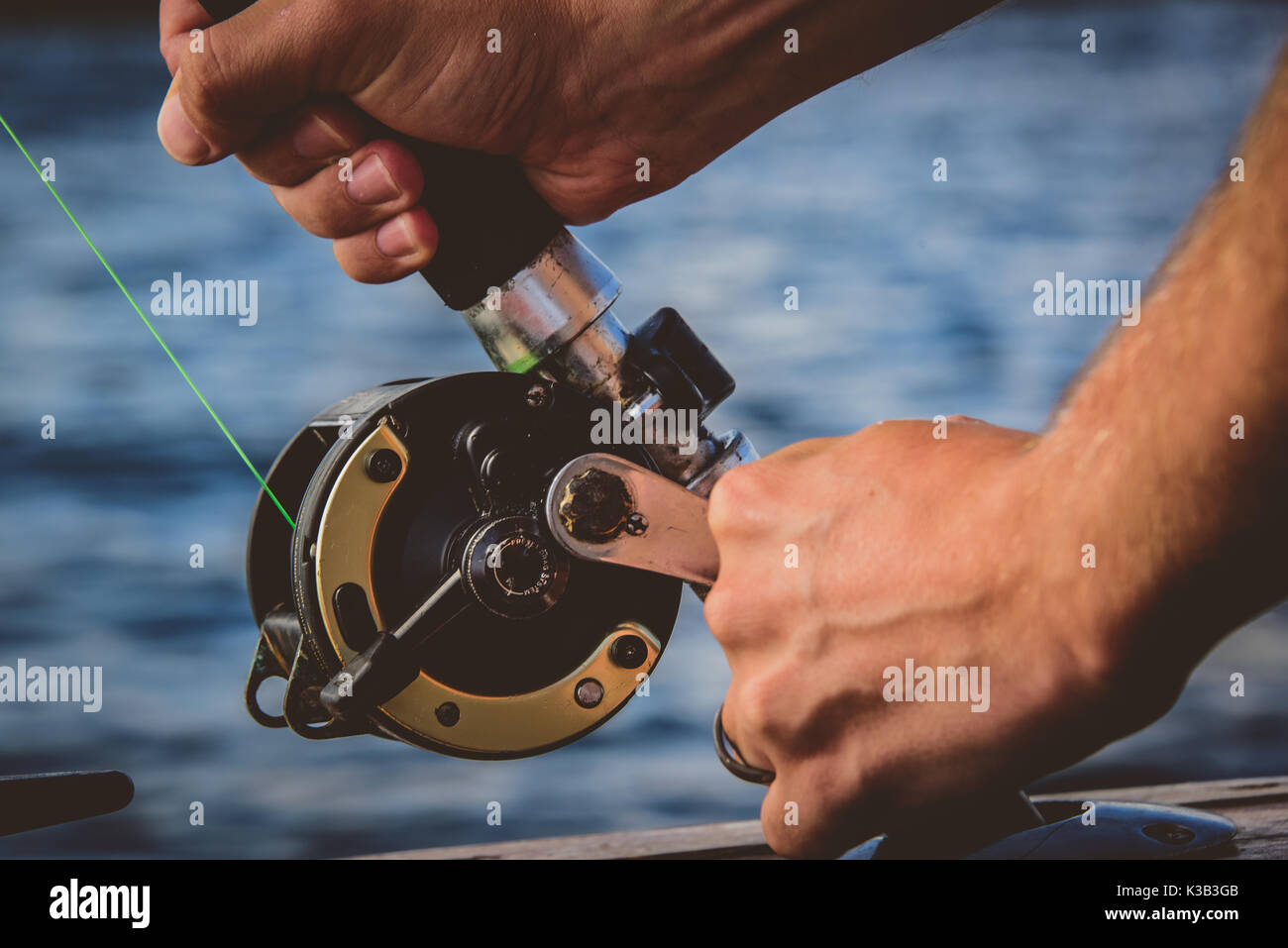 https://c8.alamy.com/comp/K3B3GB/close-up-hands-on-fishing-reel-K3B3GB.jpg