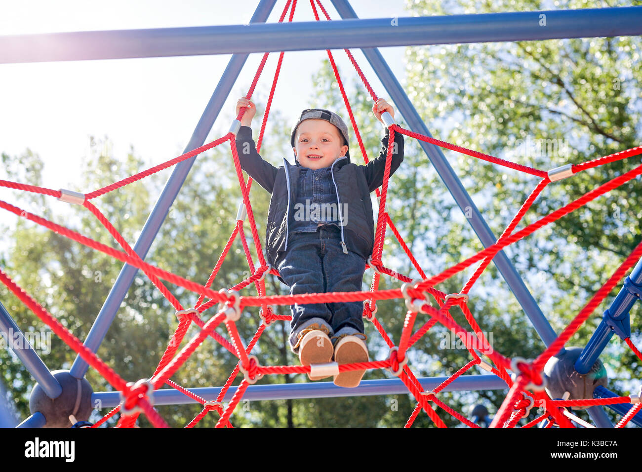 Happy little child boy climbed on playground Stock Photo