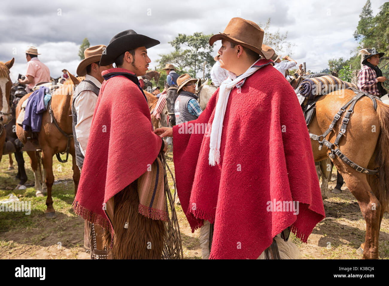 May 27, 2017 Sangolqui, Ecuador: quechua cowboys in red poncho interacting during a rural rodeo at high altitude Stock Photo