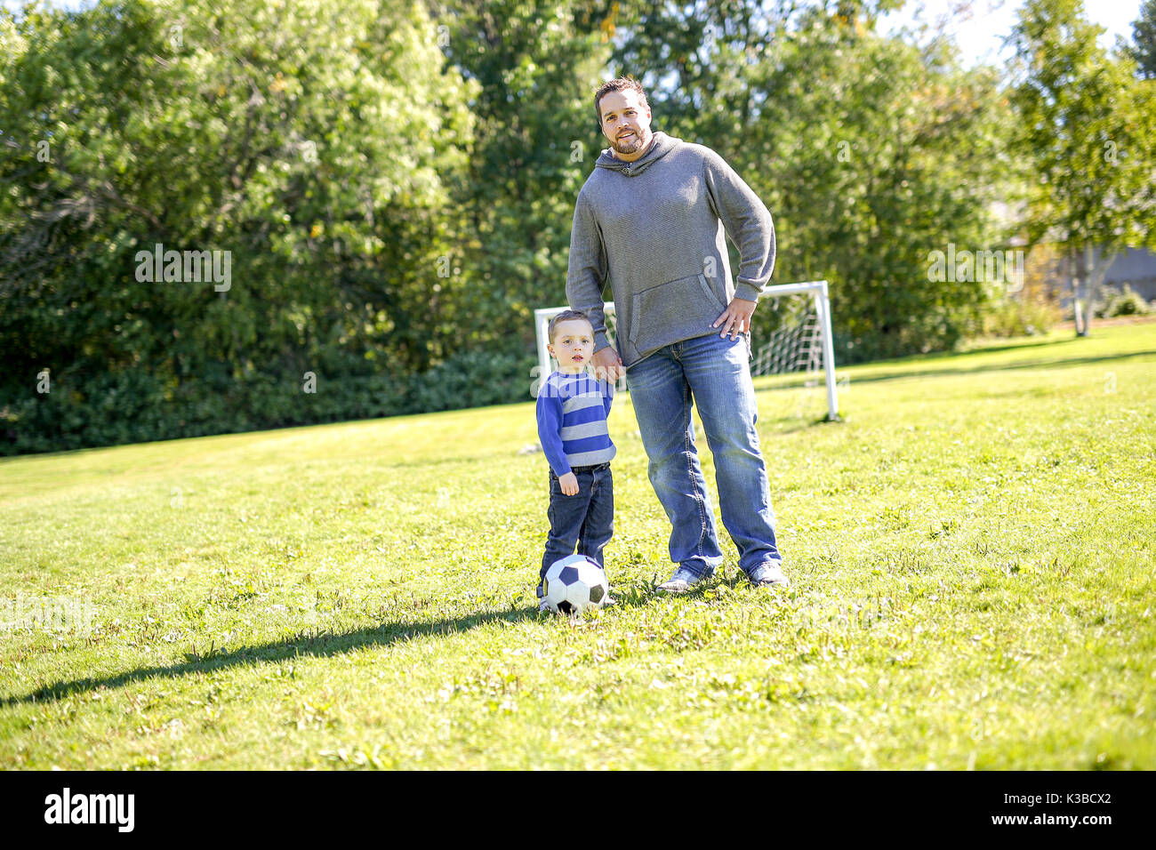 Father and Son Playing Ball in The Park Stock Photo