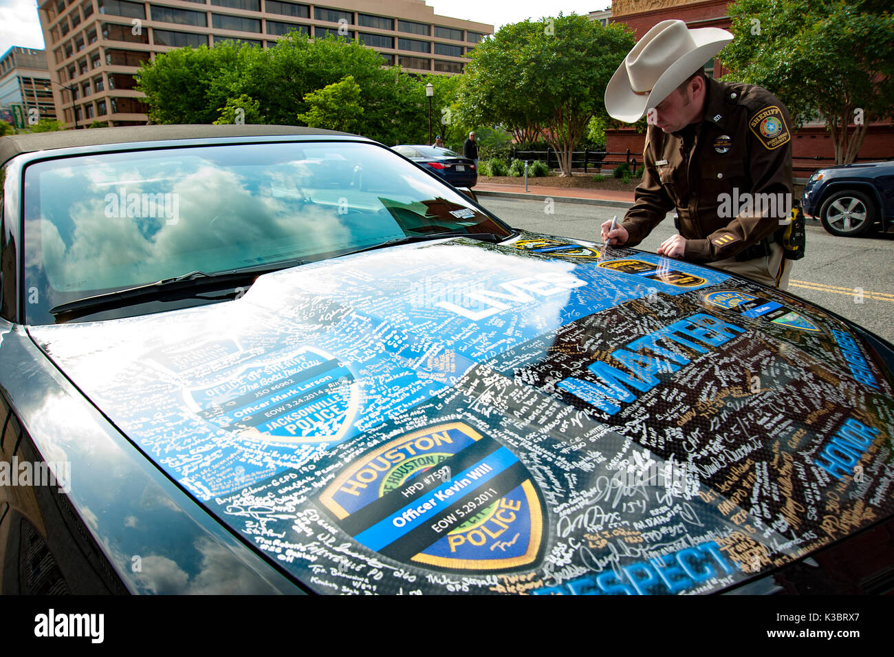 Texas ranger signing Blue Lives Matter custom car hood with signatures honoring fallen on duty Police Officers. National Police week. Washington DC Stock Photo