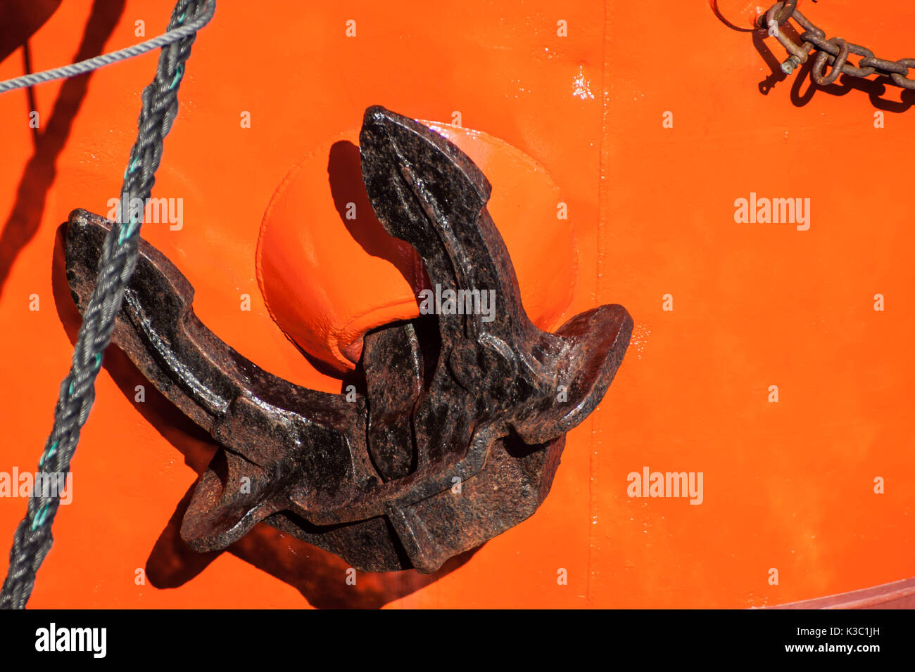 Red tugboat close up black anchor detail Stock Photo