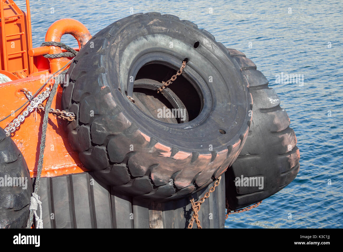 Red tugboat close up big tires protection detail Stock Photo