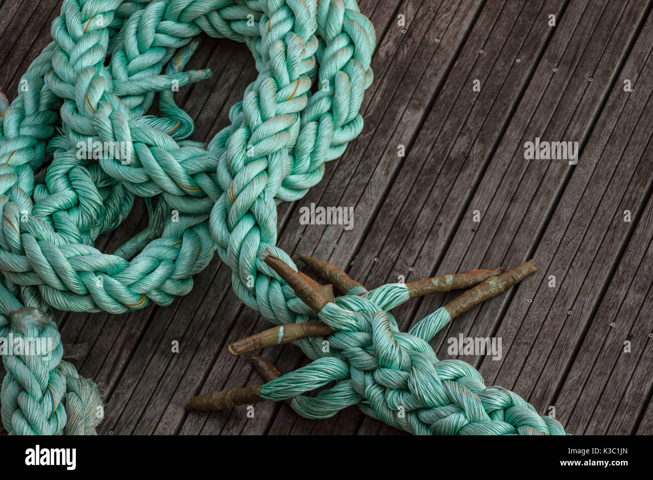 green mooring rope on the floor at the harbour dock Stock Photo