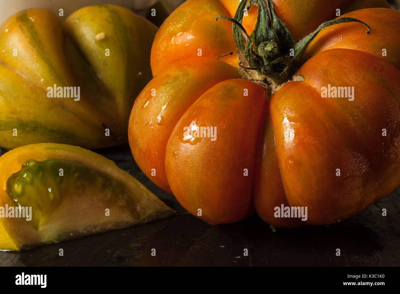 Red tomato and tomato slice with seeds close up Stock Photo