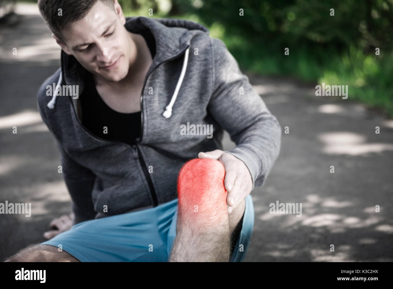 A photo of a young man having knee injury during jogging Stock Photo