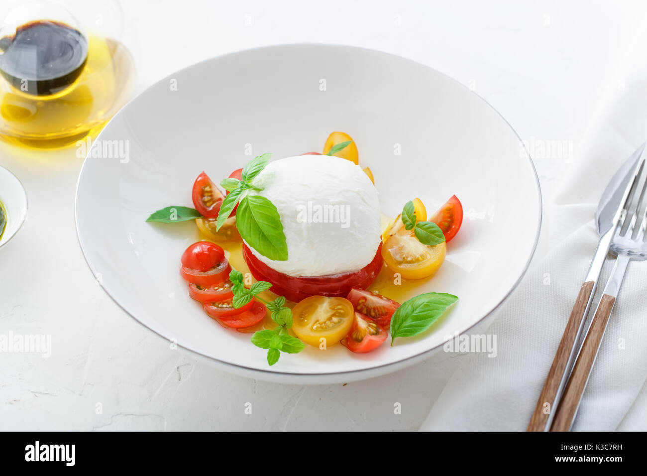 Italian appetizer caprese salad with ripe red and yellow cherry