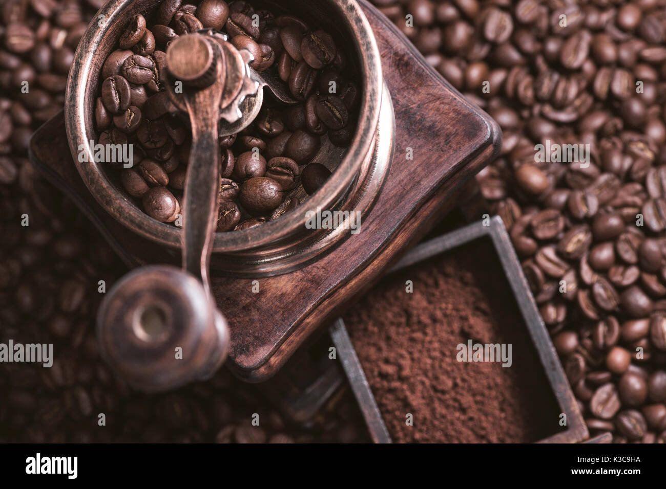 Grinding coffee from fresh roasted coffee beans. Stock Photo