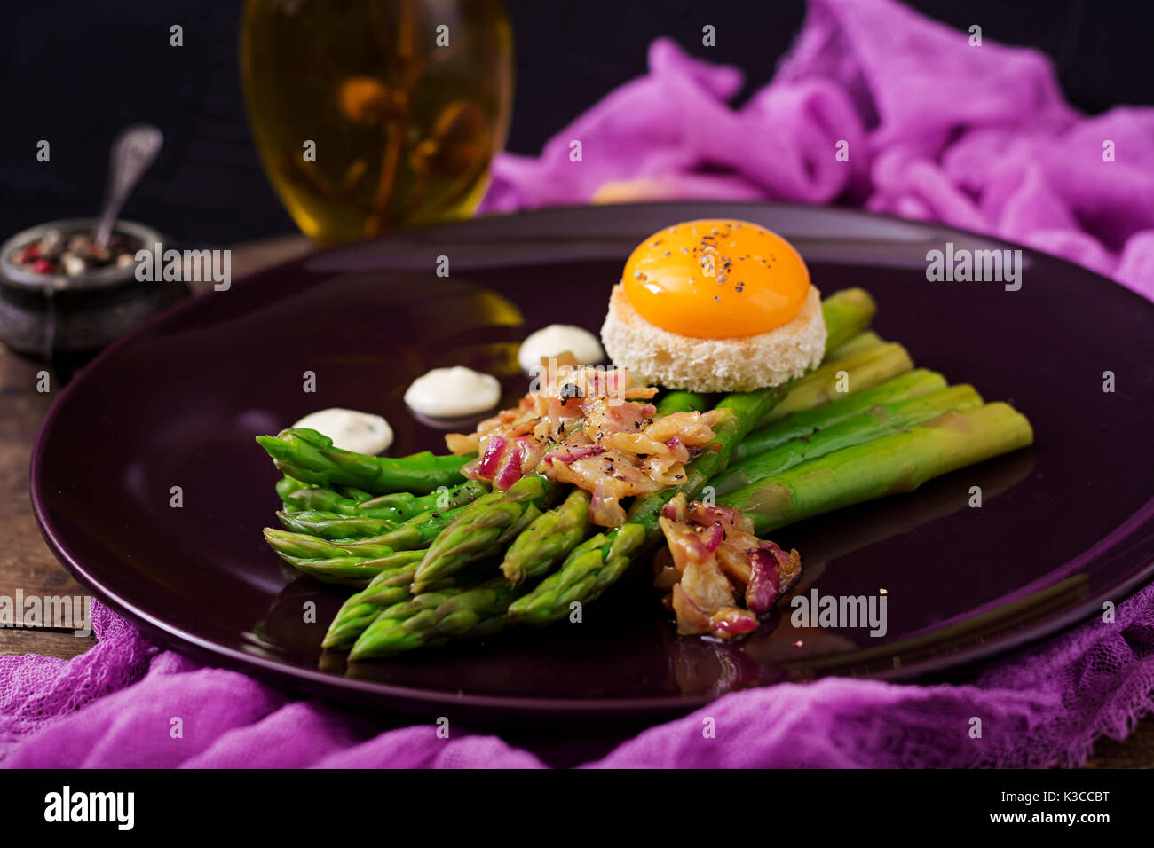 Young shoots of asparagus with ham and chicken egg yolk on toast Stock