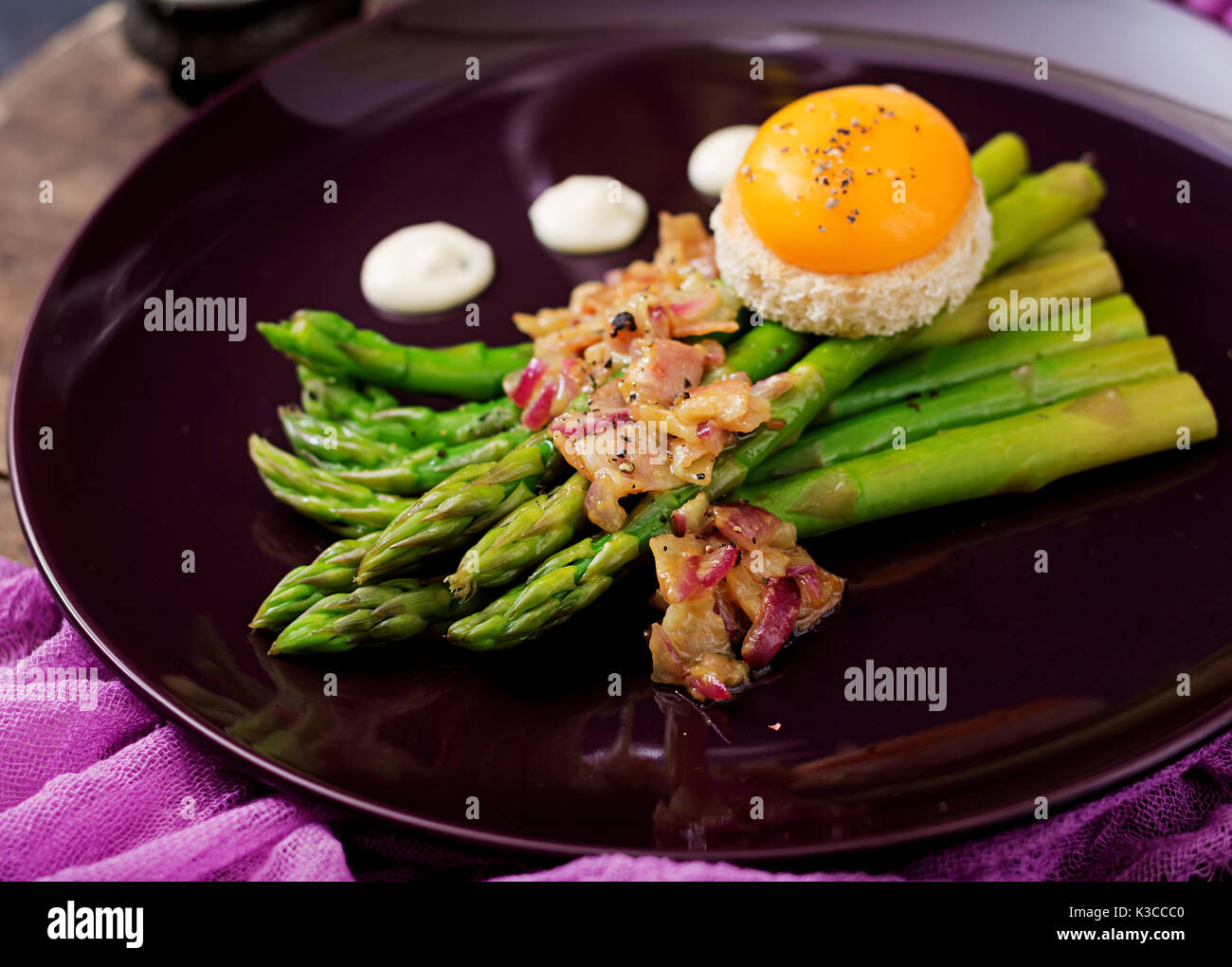 Young shoots of asparagus with ham and chicken egg yolk on toast Stock