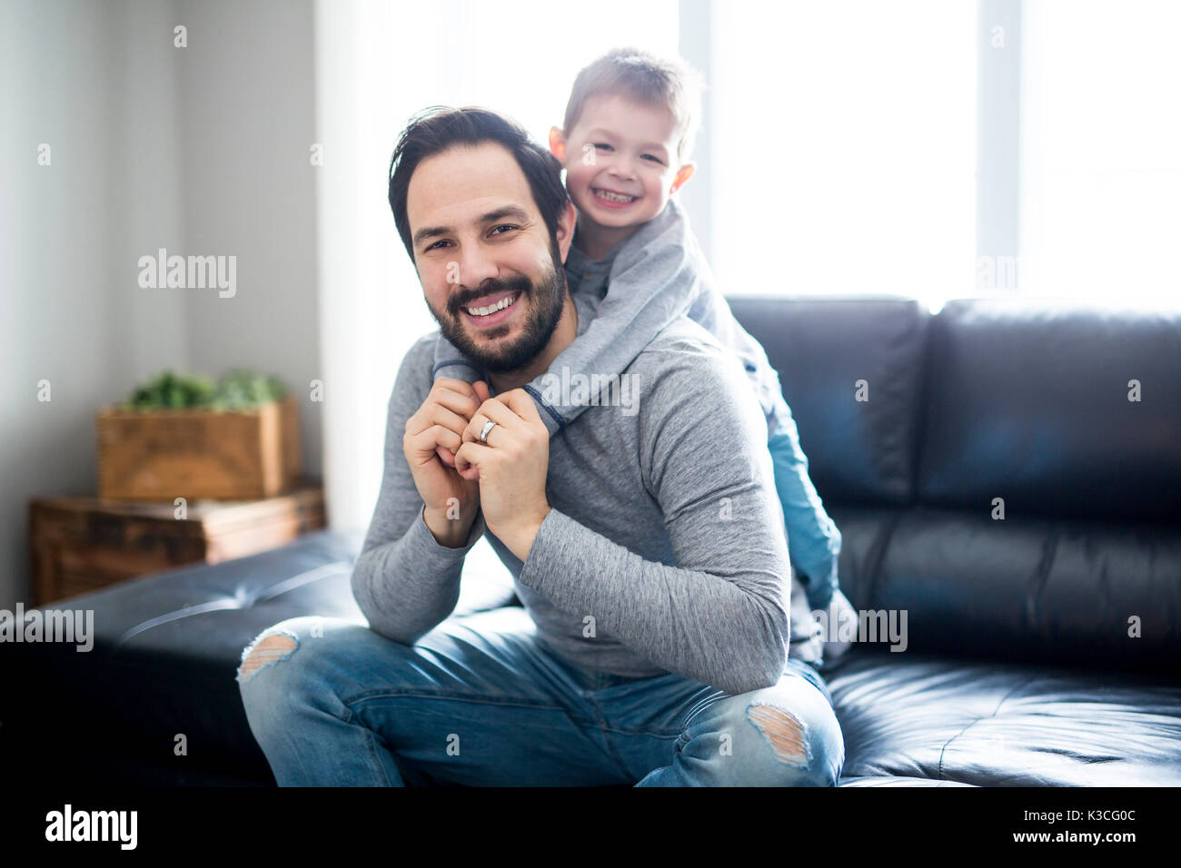 Father And Children On Sofa At Home Watching TV Together Stock Photo