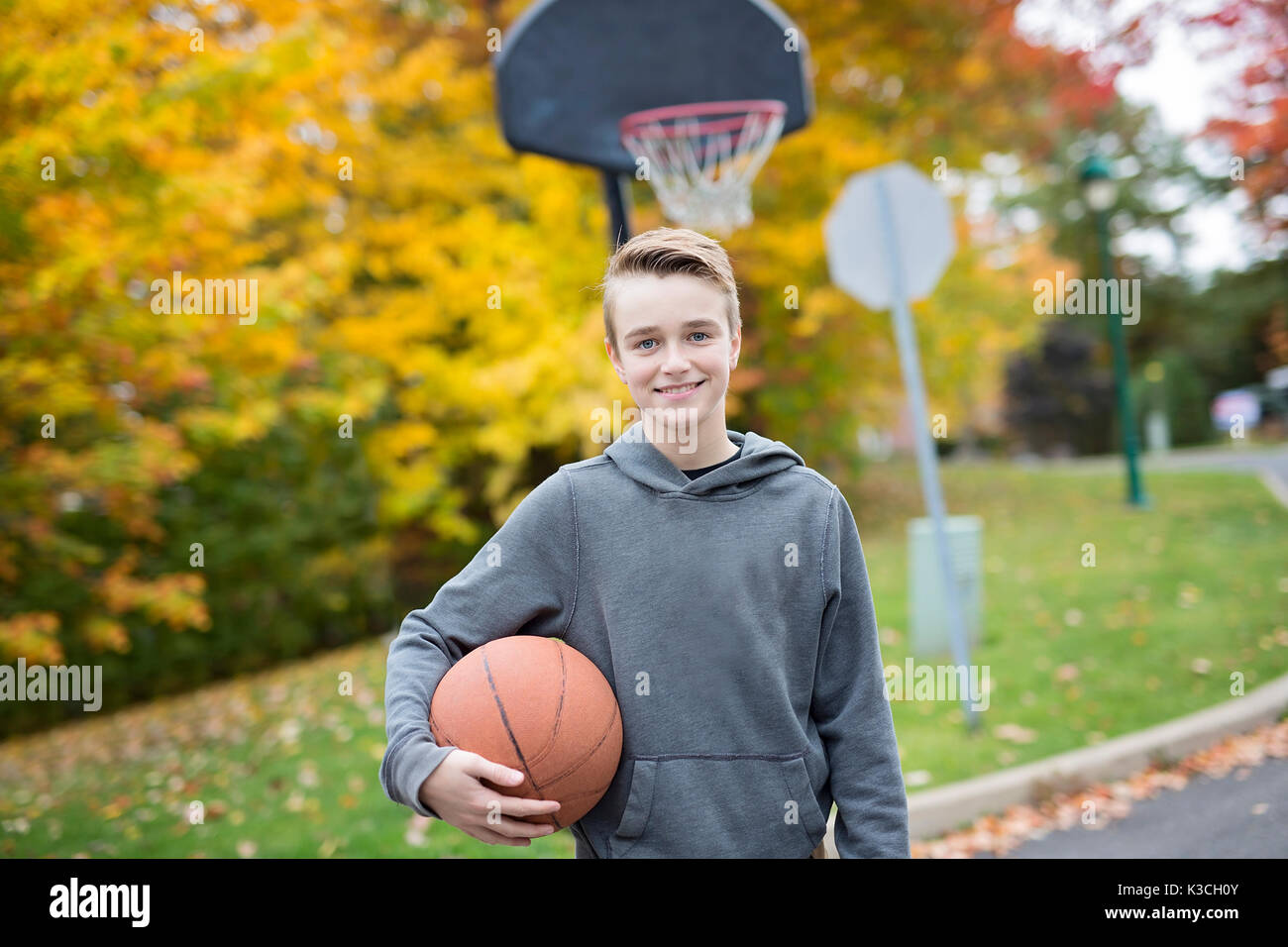 Boy alone during basketball game outside Stock Photo