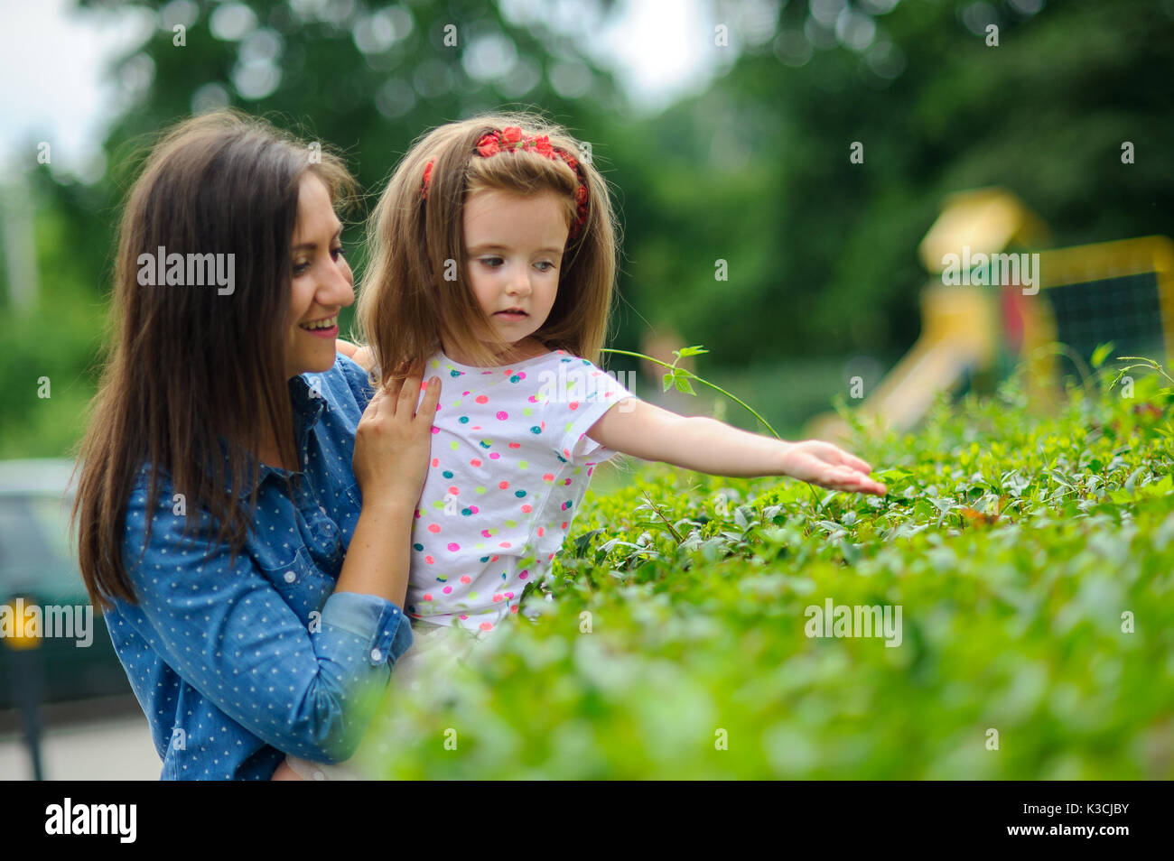 The young woman holds the little daughter on hands. Mother gently ...