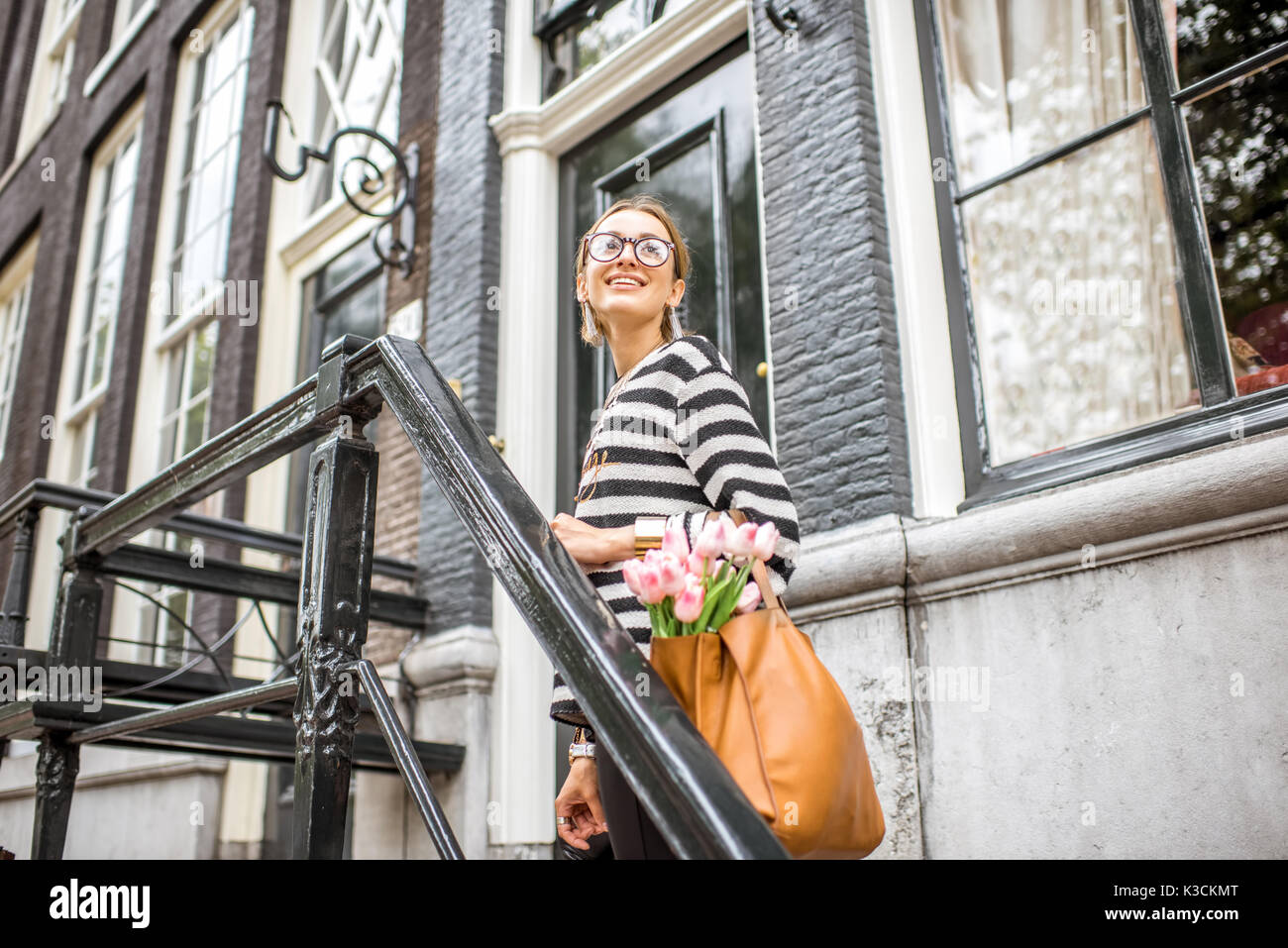 Woman on the stairs near luxury house Stock Photo