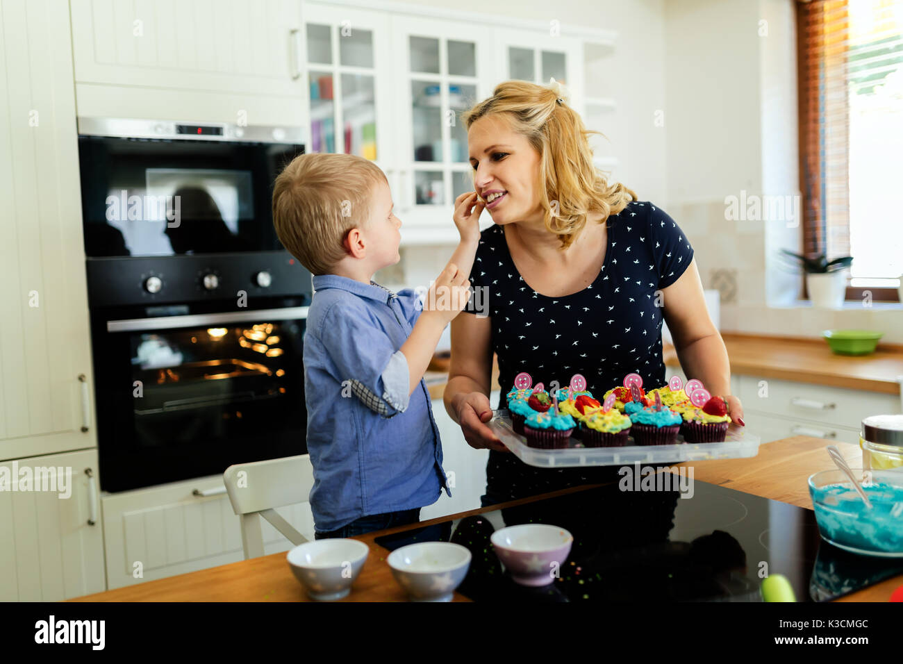 Child Helping In Kitchen Smart cute child helping mother in kitchen Stock Photo - Alamy