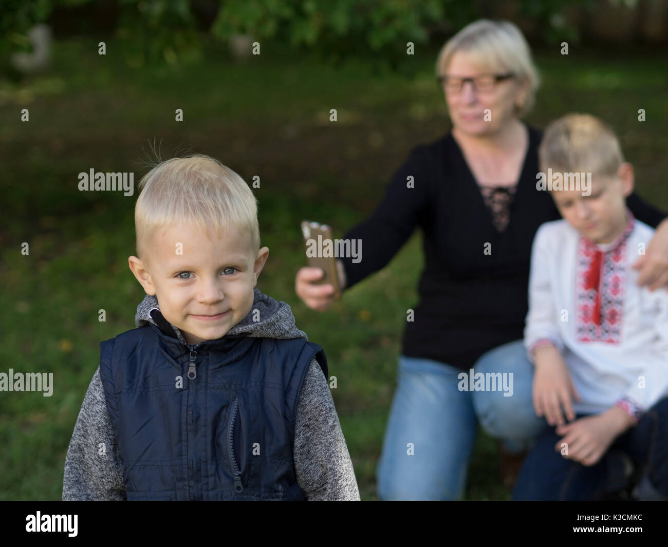 Middle-aged caucasian woman make selfie with her grandsons in the park Stock Photo