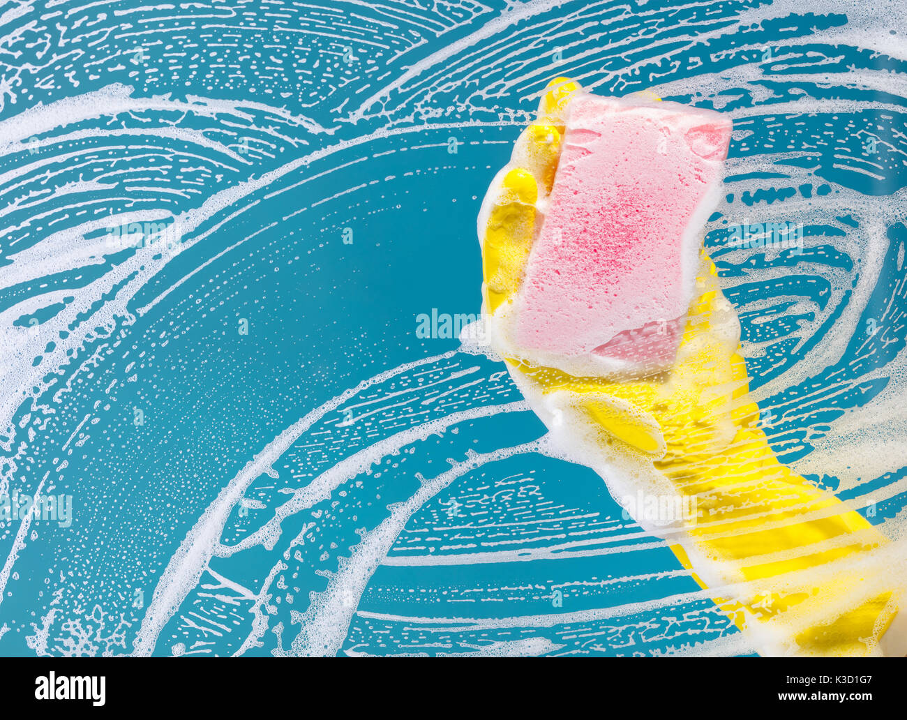 Cleaning conept, hand cleaning glass window pane with detergent and wipe or sponge Stock Photo