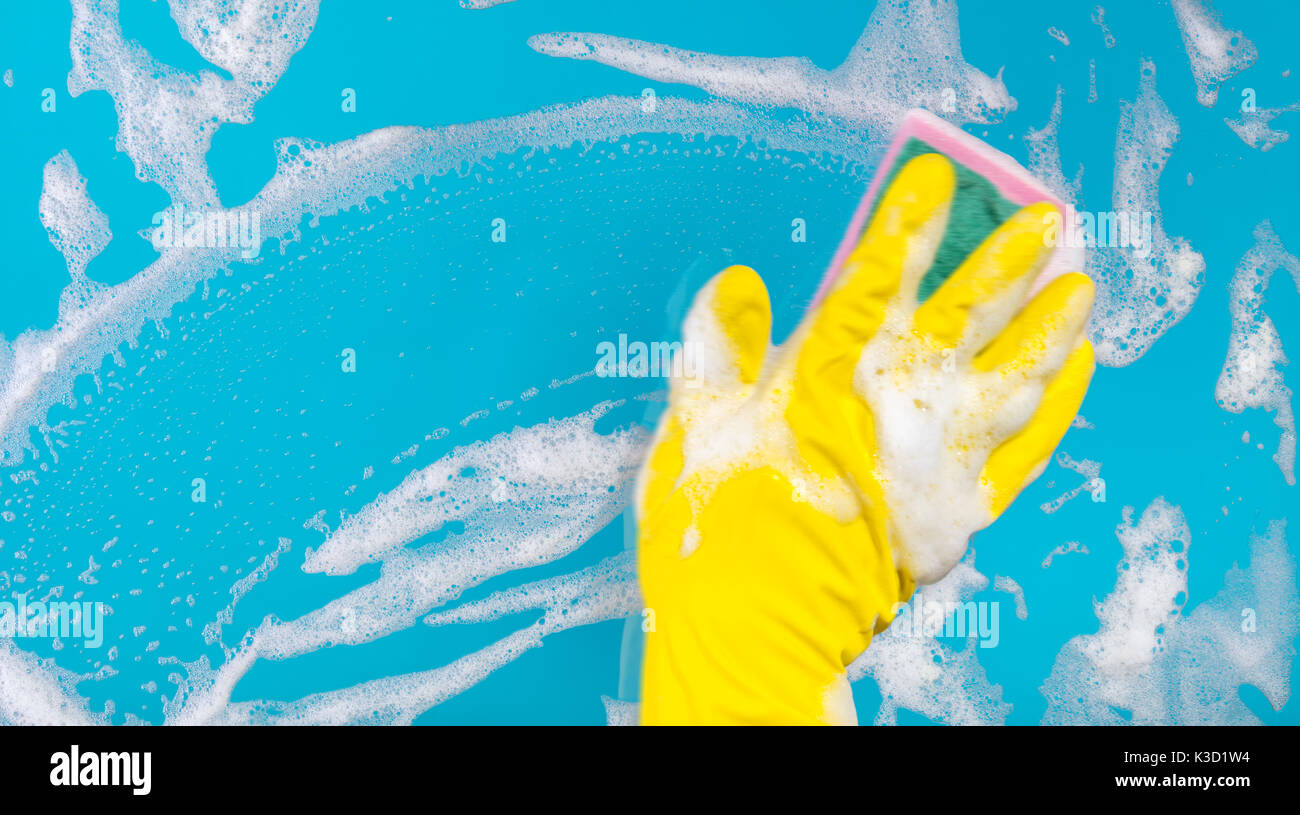 Cleaning conept, hand cleaning glass window pane with detergent and wipe or sponge Stock Photo