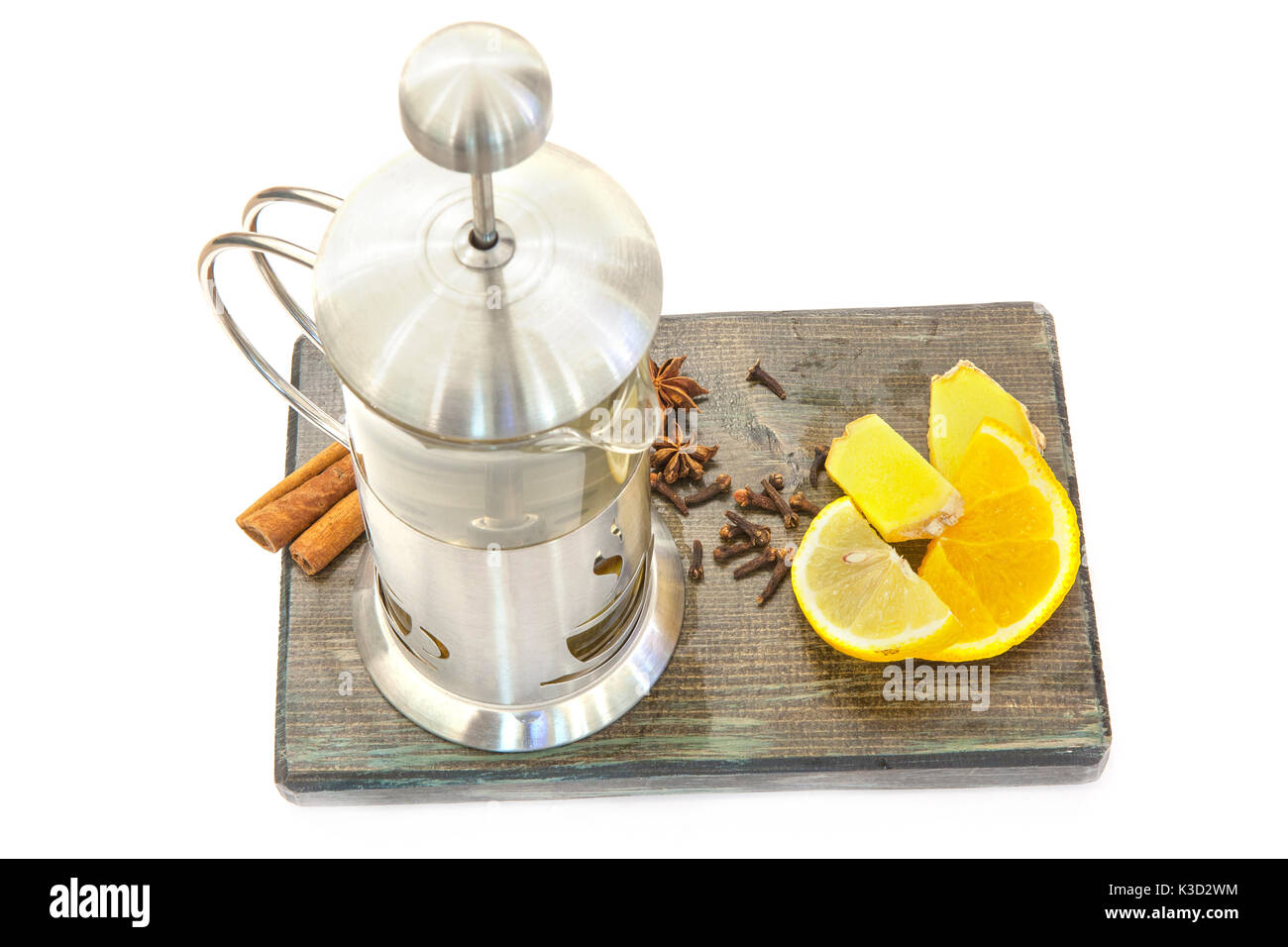 Glass teapot with green tea. Ginger tea with lemon and cinnamon on a wooden board Stock Photo