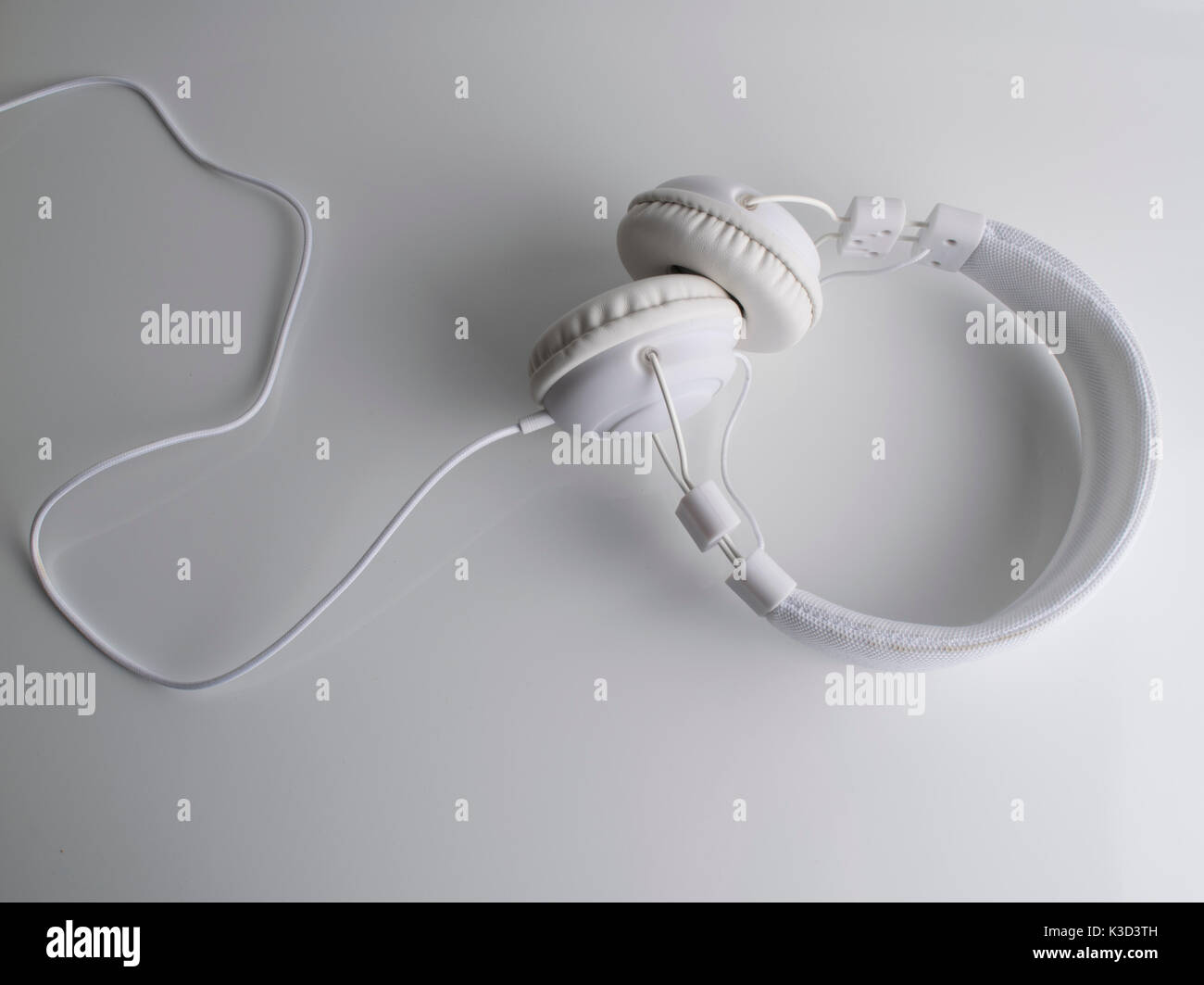 Isolated modern white headphone over a white reflected background. Stock Photo