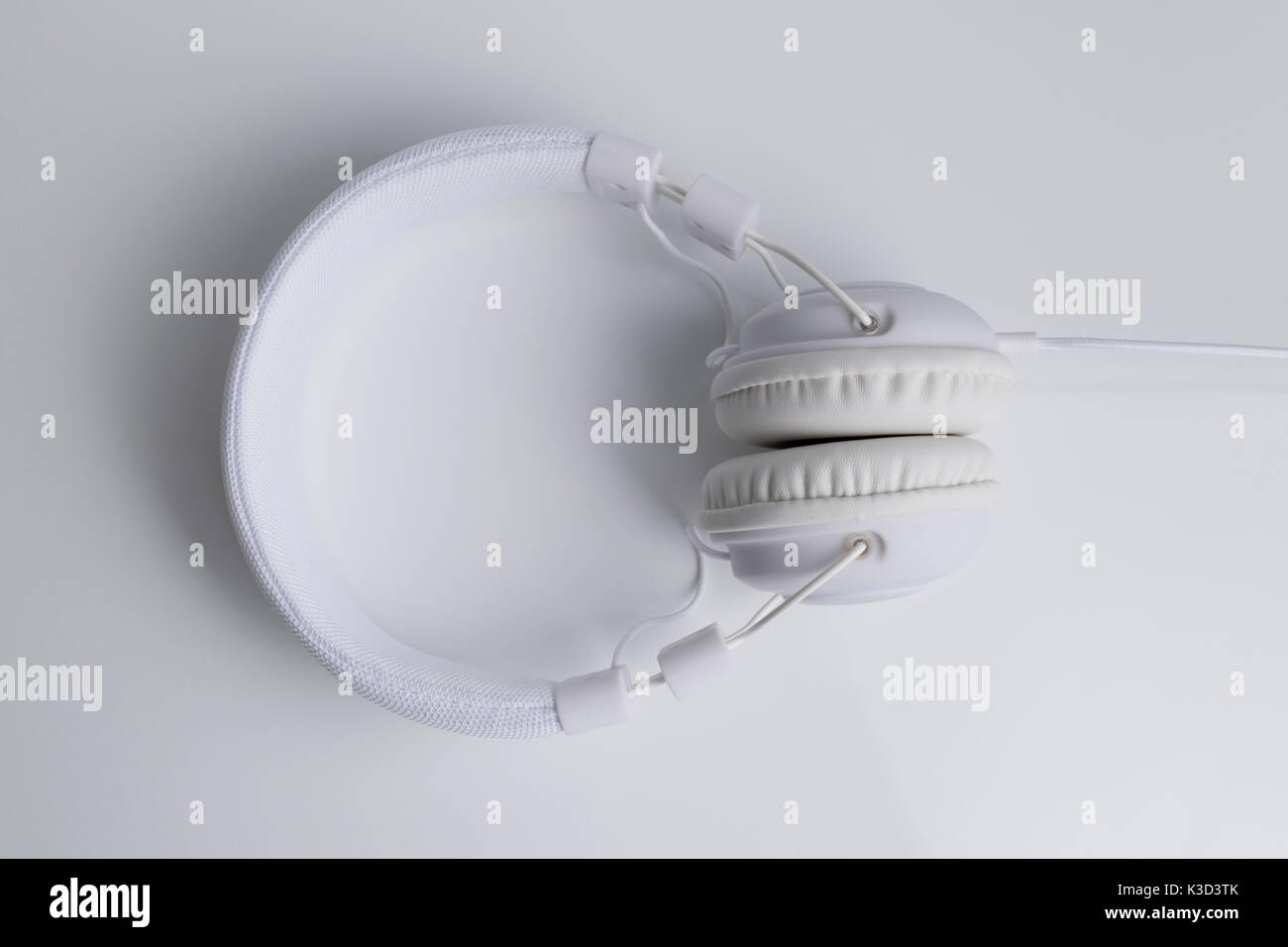 Isolated modern white headphone over a white reflected background. Stock Photo