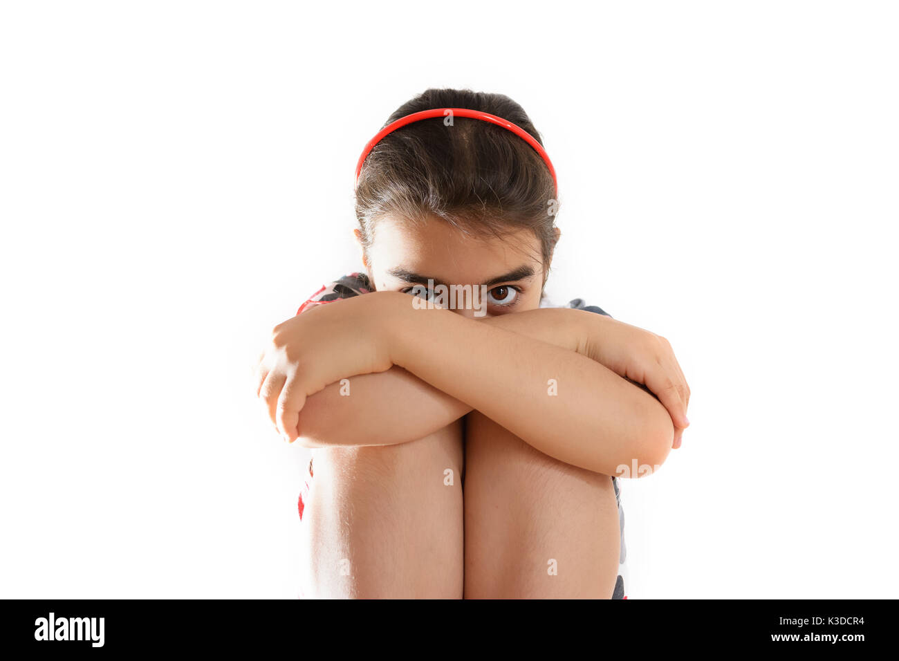 A Baby girl with her head hiding in her arms Stock Photo