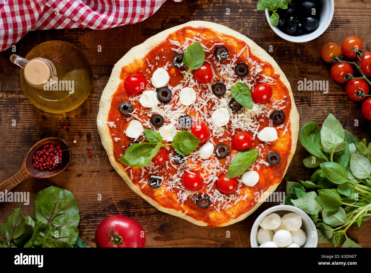 Hot italian pizza with olives, tomatoes, basil, cheese mozzarella. Top view Stock Photo