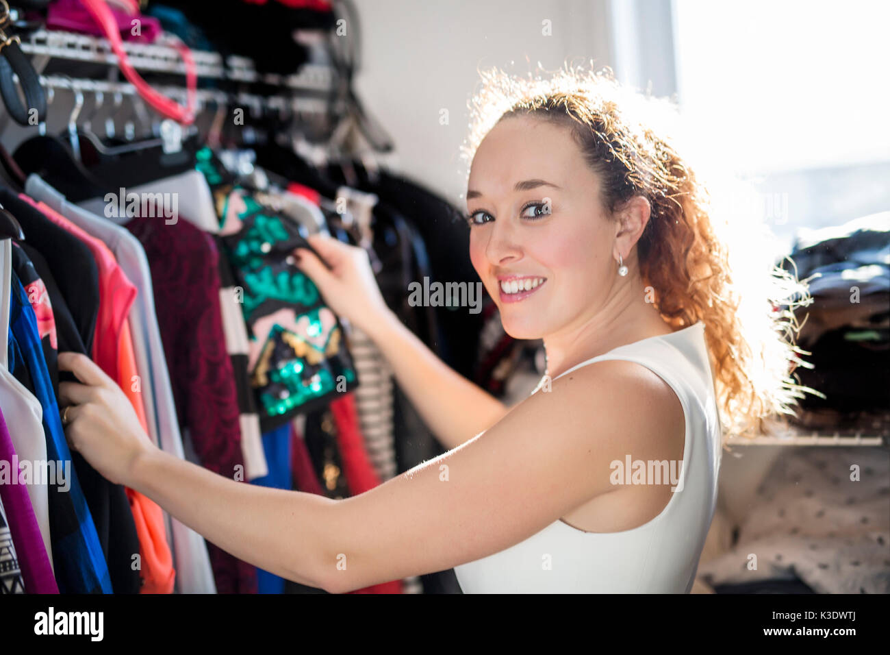 Young woman choosing an outfit to wear. Stock Photo
