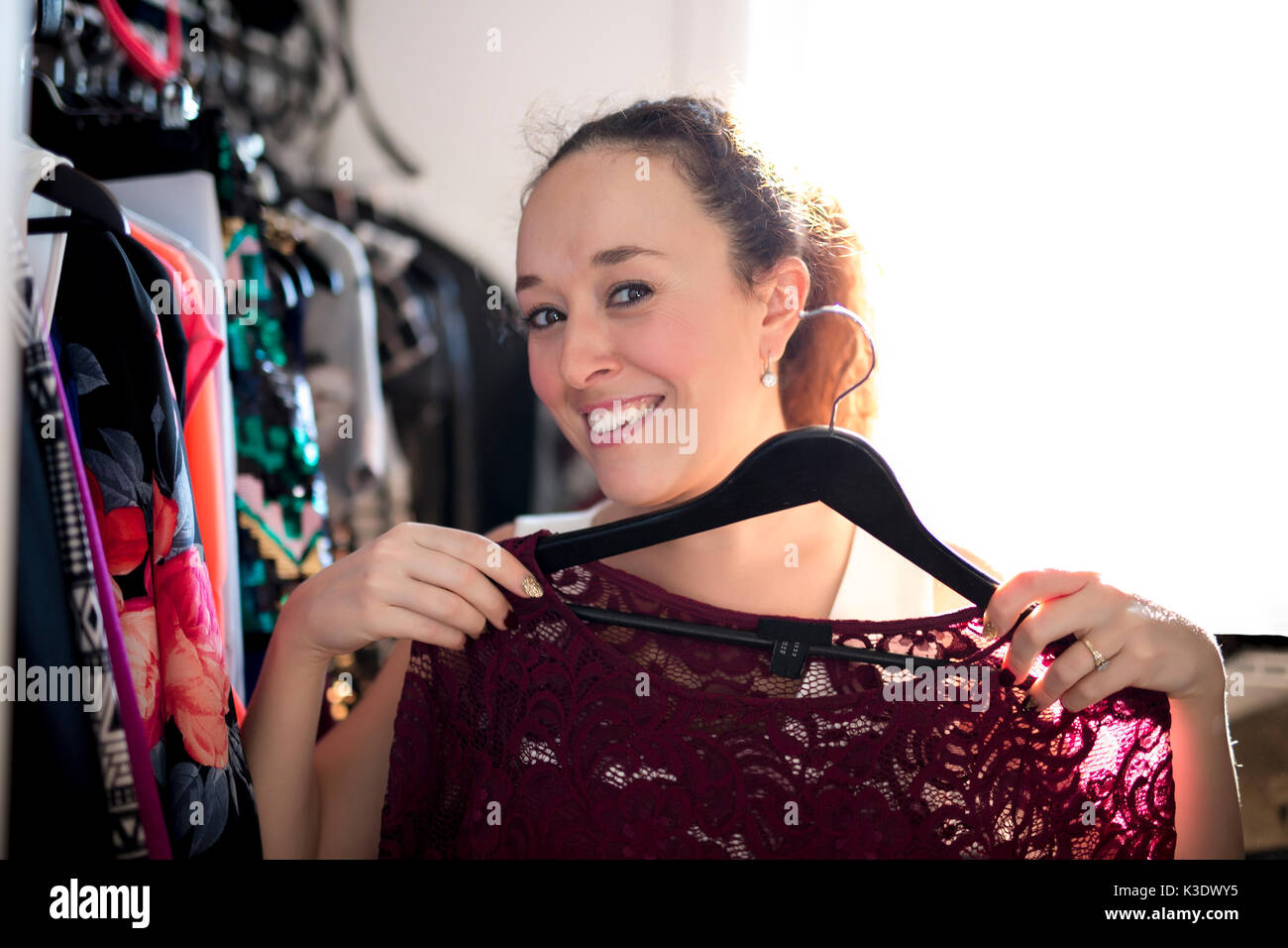 Young woman choosing an outfit to wear. Stock Photo