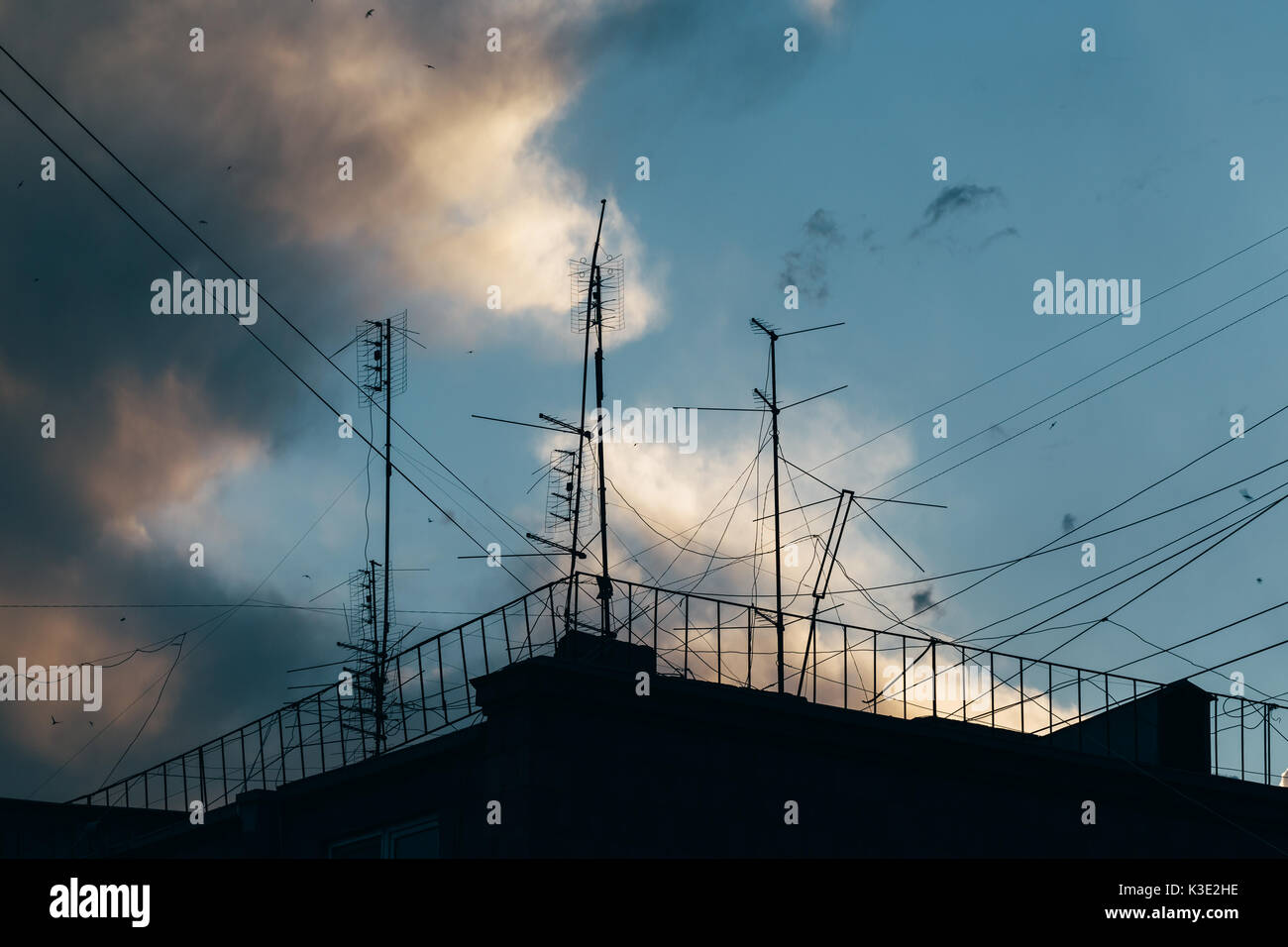 Television antennas and wires on the roof of an apartment house Stock Photo