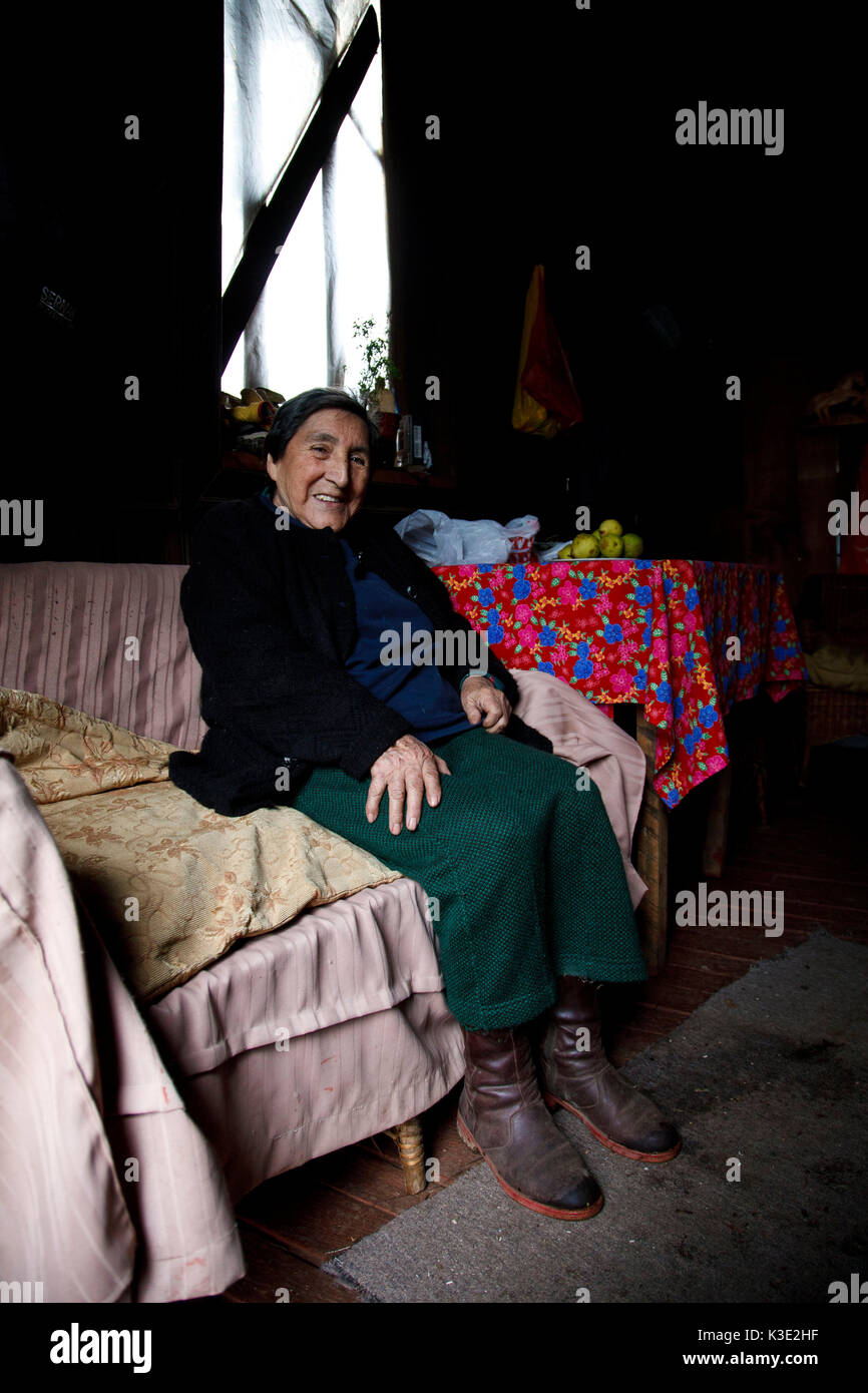 Chile, Araucania, Curacautin, Mapuche, woman, sofa, sit, Stock Photo