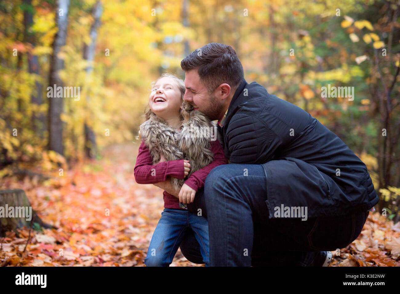 Little adorable girl with happy father in autumn park outdoors Stock Photo