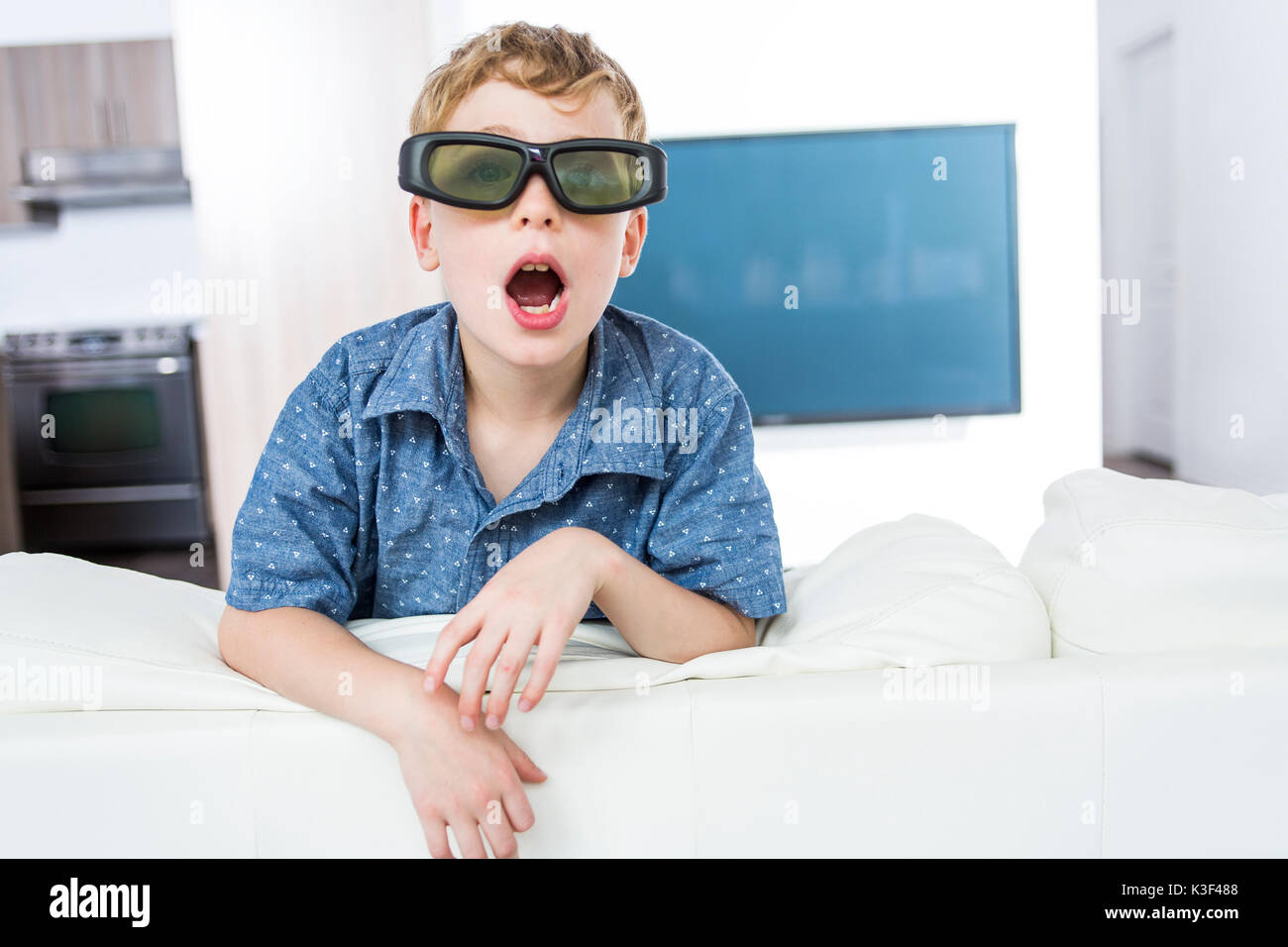 Little boy wearing 3D glasses and watching television Stock Photo Alamy
