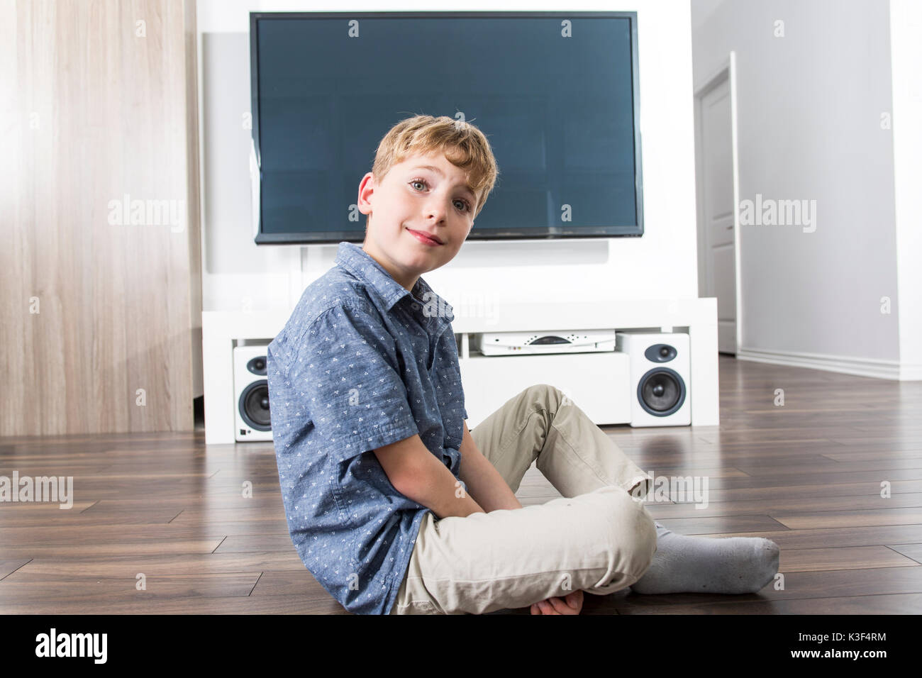 Rear view of little boy sitting on the floor and watching cinema Stock ...