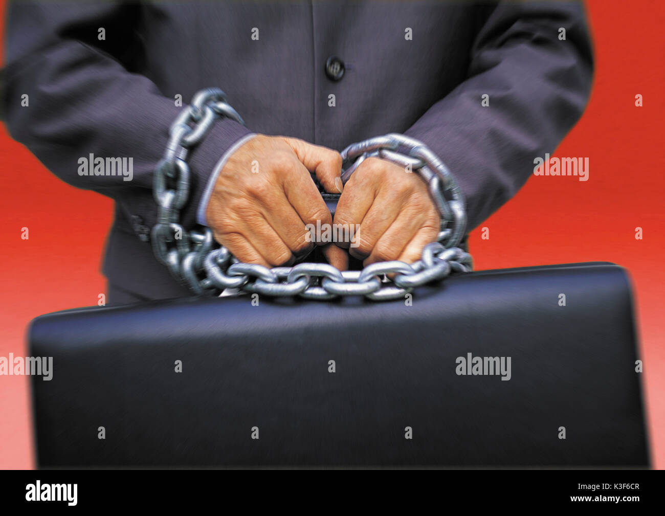 Man holds briefcase with tied up hands Stock Photo