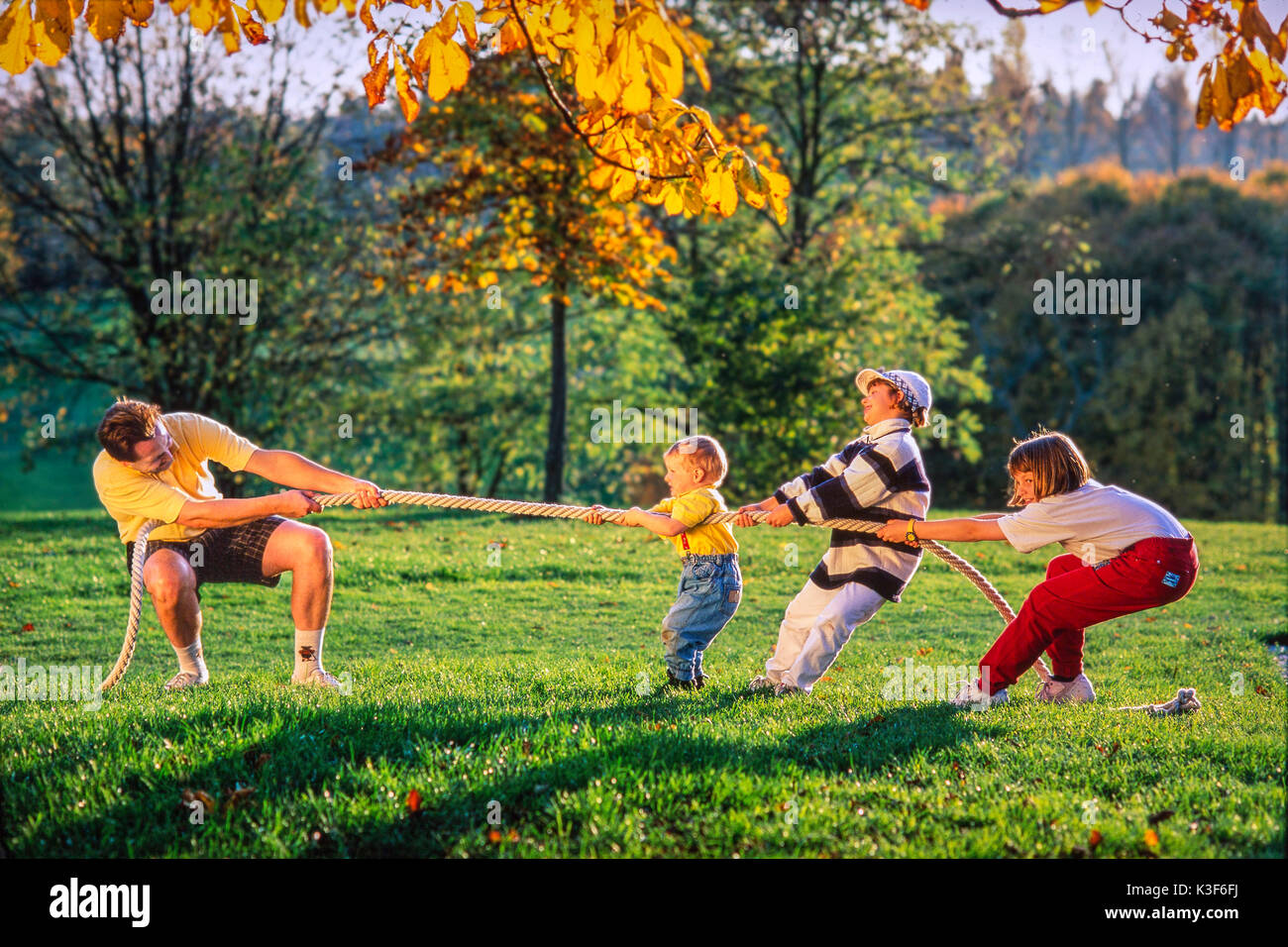 Father with children while the tug of war Stock Photo