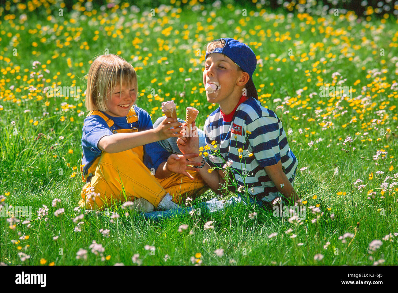 Children eat ice in spring meadow Stock Photo