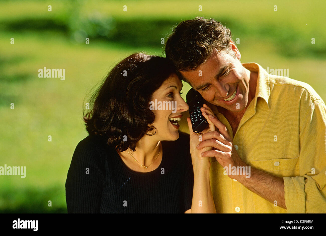 Laughing couple is phoning with a mobile Stock Photo