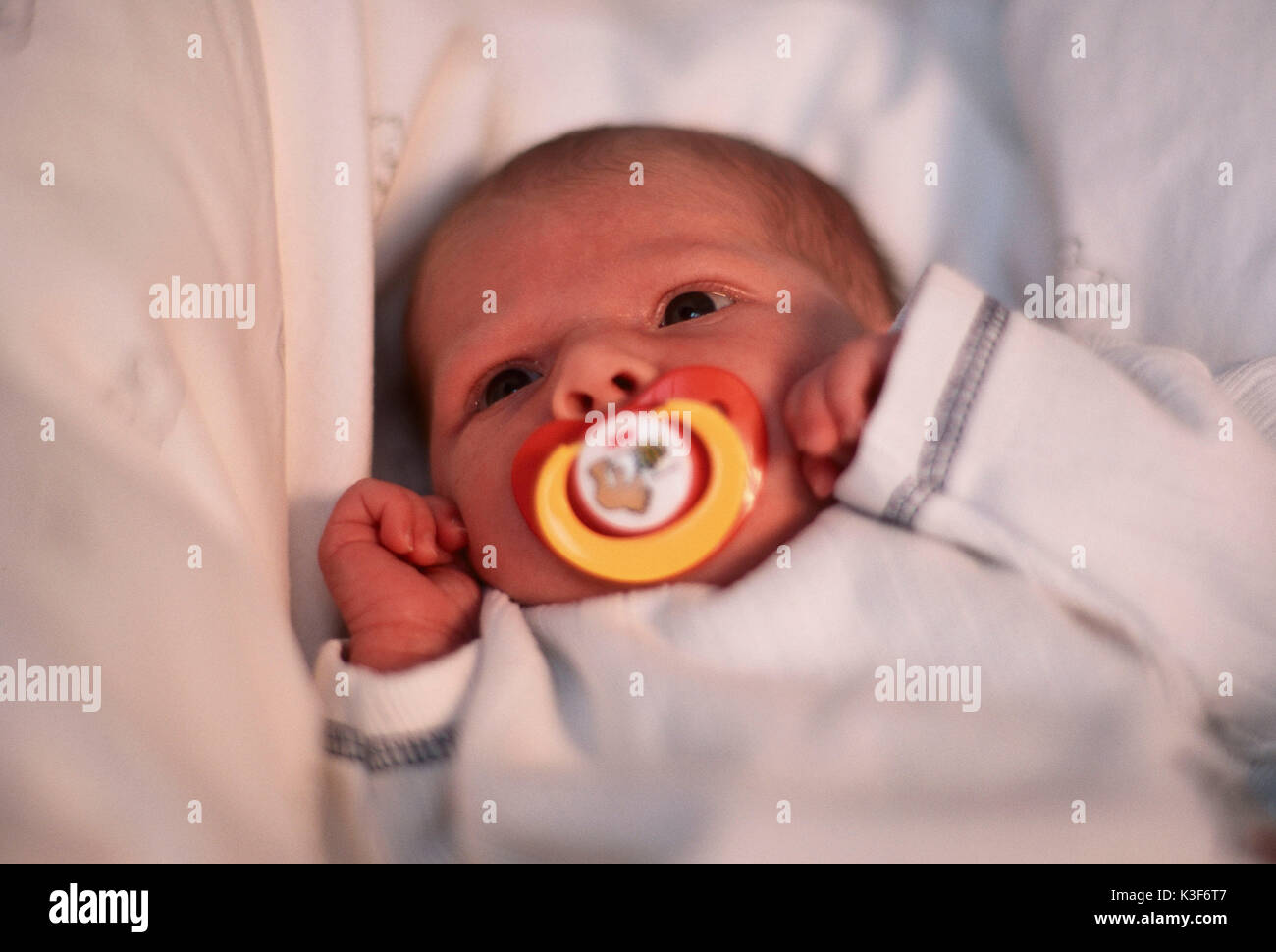 On the back lying baby with dummy in the mouth Stock Photo