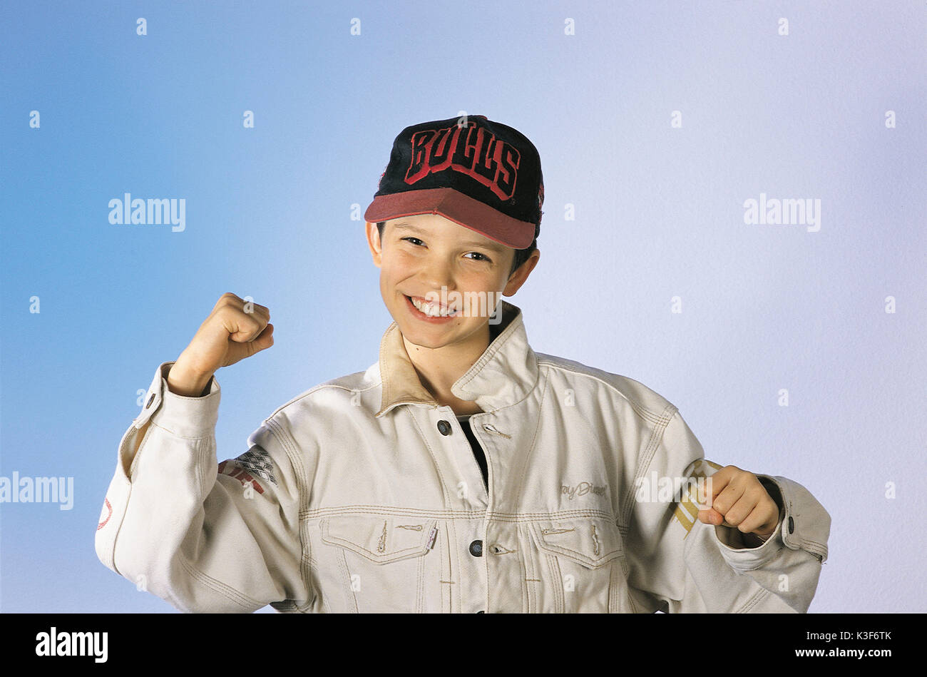 Boy rejoices, is pleased, laughs, travels an arm upwards Stock Photo