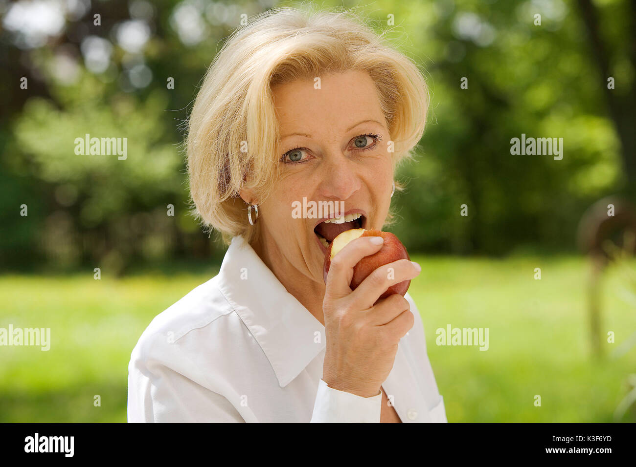 Woman bites in an apple Stock Photo