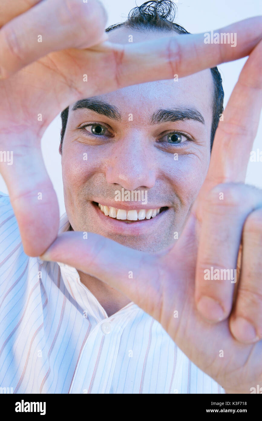 Man forms a rectangle with his hands and looks through Stock Photo
