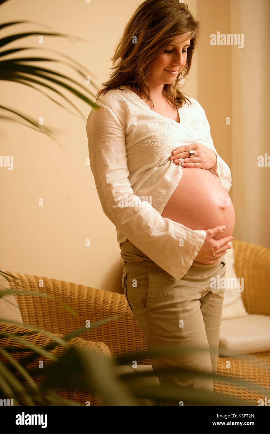 Pregnant young woman keeps the abdomen Stock Photo