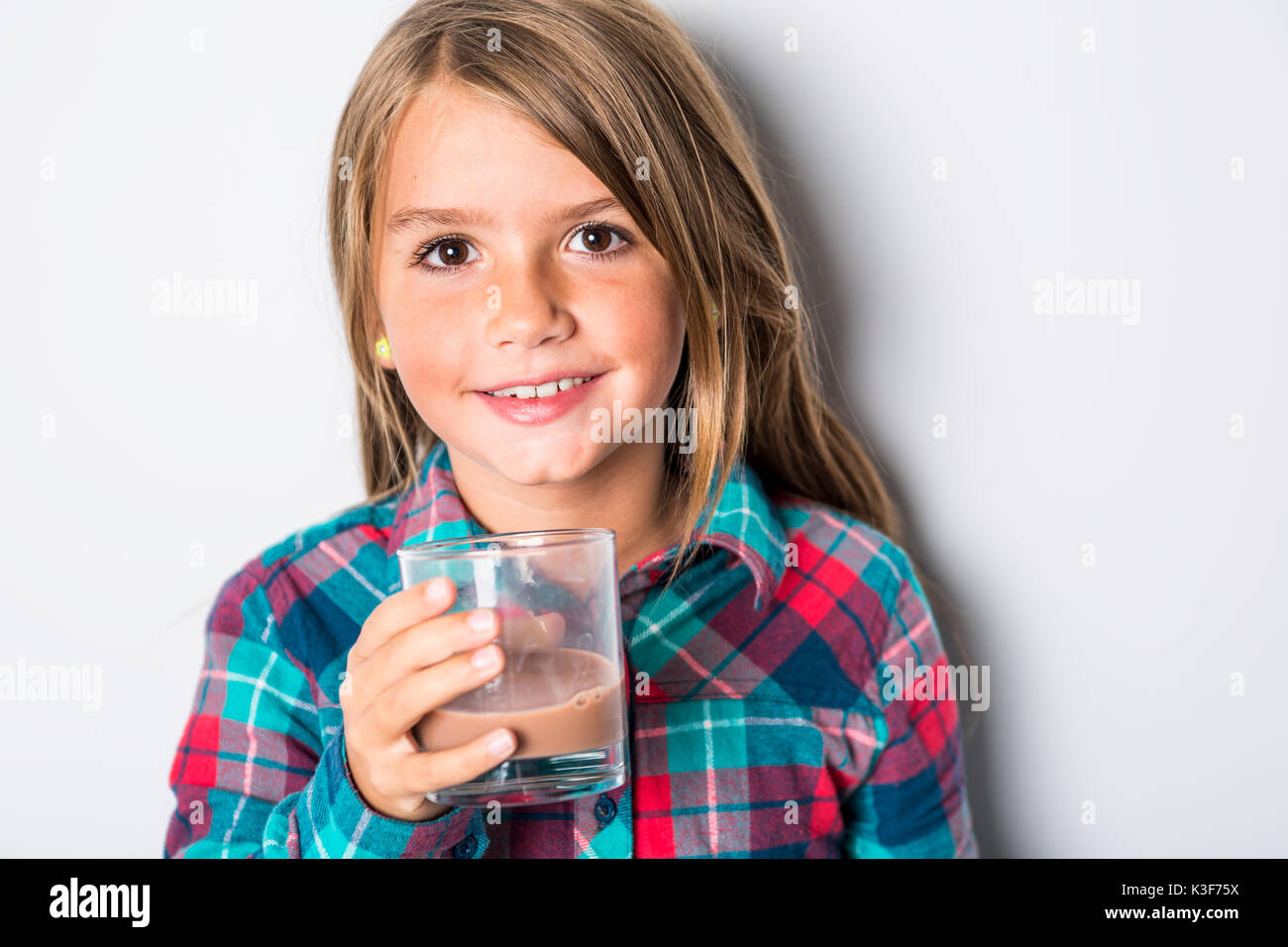 Happy smiling child drinking chocolate milk isolated on white Stock Photo Alamy