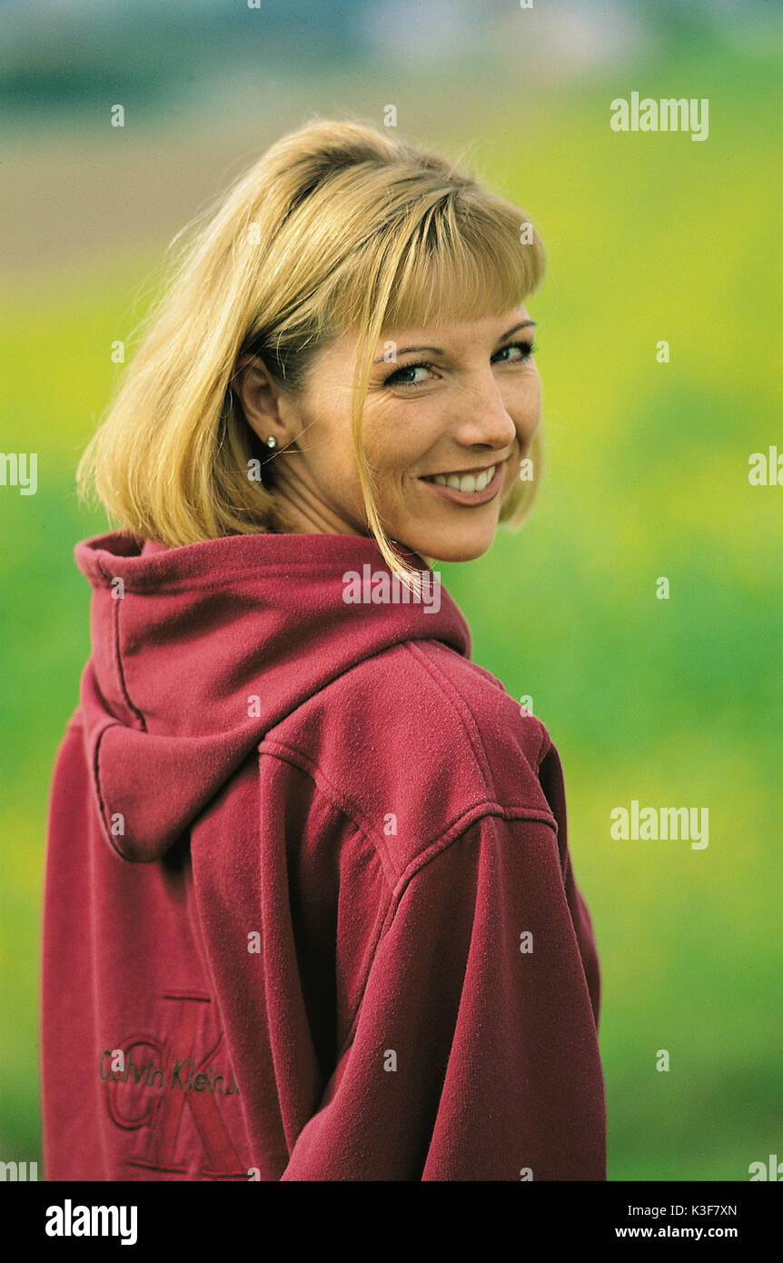 Laughing young woman turns round and looks over the shoulder Stock Photo