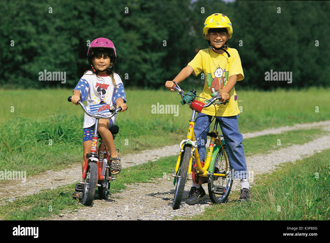 Two children by bicycle on a country lane Stock Photo