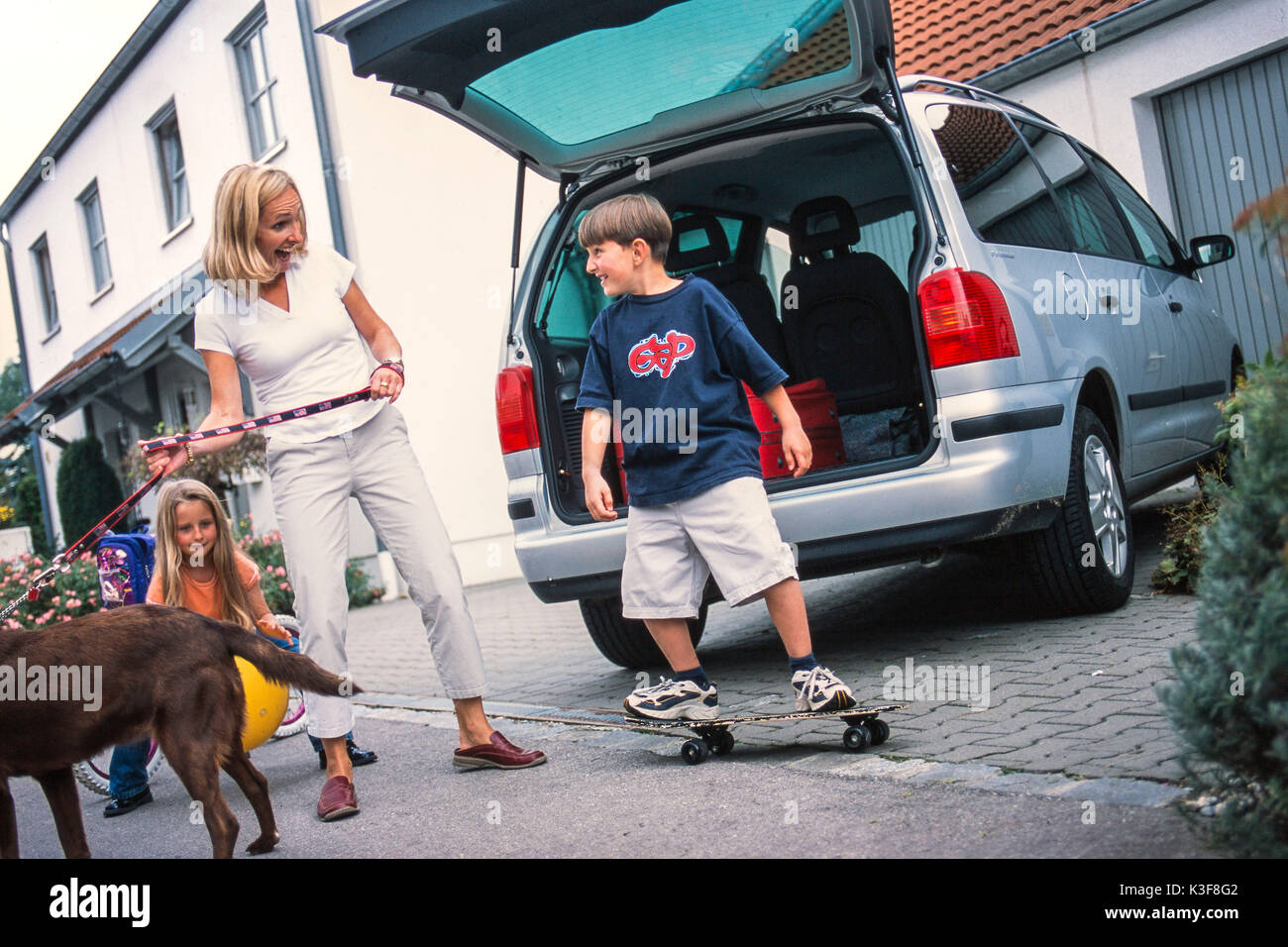 Motherwith children while charging the car Stock Photo