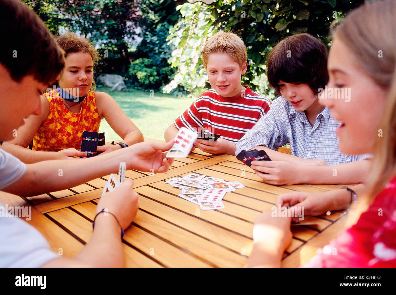 Group of children / of young persons playing cards Stock Photo