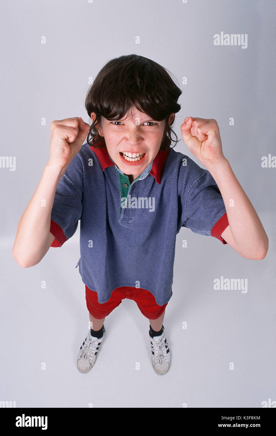 boy with furious expression clenches his fists Stock Photo