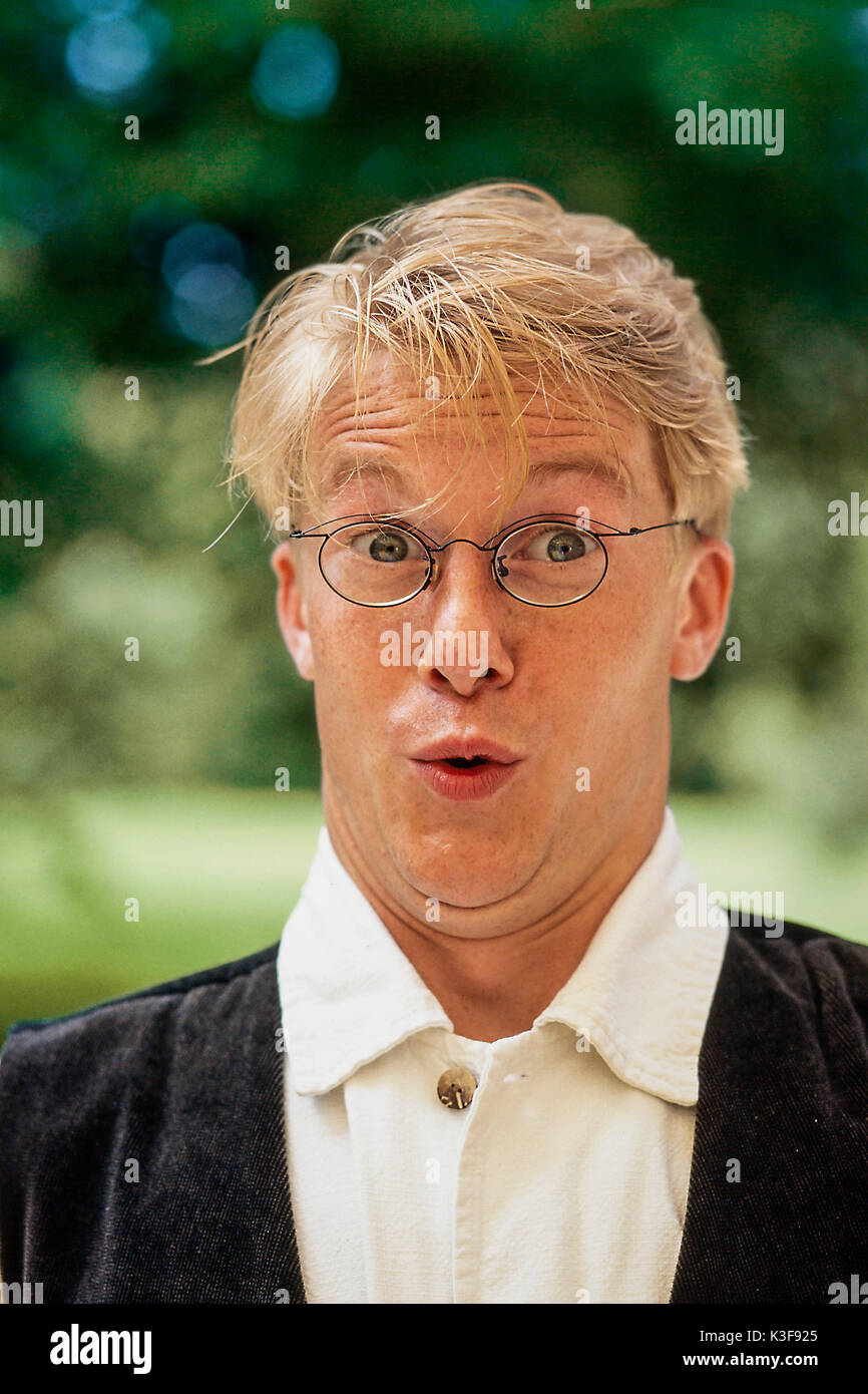 Blond man with glasses makes an amazed look Stock Photo